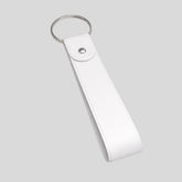 Stockk White faux leather loop keychain with metal ring and snap closure. Customizable for branding.