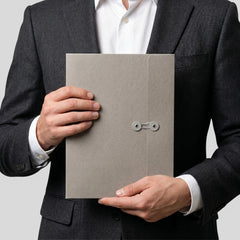 Stockka A4 grey cardboard marketing folder with string closure and circular holders, held by a man in a suit.