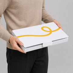 Stockka A4 rigid cardboard presentation folder with yellow ribbon design and closure tab, held by a person.