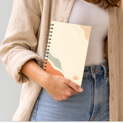 Stockka cream spiral notebook with abstract orange, blue, and beige wavy design. Features 80 lined pages and a hard cover.