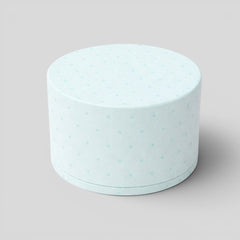Stockka light blue cylindrical jewelry box with a removable lid and a subtle polka dot pattern, made of textured cardstock.