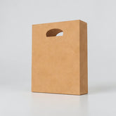 Stockka brown kraft paper shopping bag with die-cut handle, ideal for retail and branding.