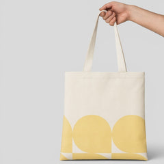 Stockka natural cotton canvas tote bag with a yellow geometric circle pattern. Reusable and ideal for custom printing.