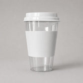 Stockka clear PET plastic cup with white cardboard sleeve and flat lid, ideal for cold drinks and takeaway.