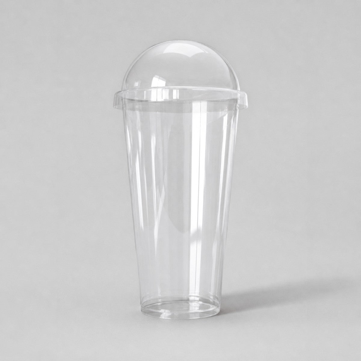 Stockka tall clear PET plastic cup with dome lid, ideal for smoothies and cold drinks.