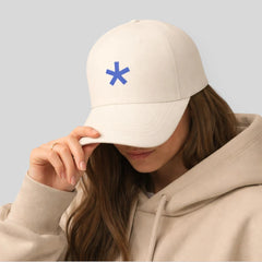 Stockka classic baseball cap in cream cotton with a blue asterisk logo. Adjustable unisex fit.