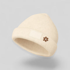 Stockka cream acrylic knit beanie with a small brown flower embroidery and a blank patch.