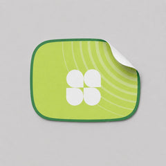 Stockka custom die-cut sticker with a green background and a white four-petal logo. Features concentric green lines.