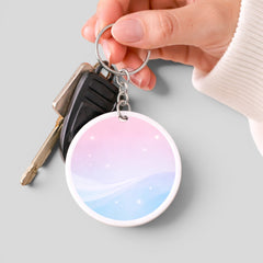 Stockka custom round acrylic keychain with glossy finish, pink and blue gradient, and sparkling stars design, attached to keys.