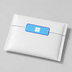 Stockka custom rectangular sticker with rounded corners, blue striped background and white four-petal flower logo, applied to a white padded envelope.