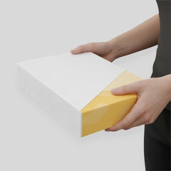 Stockka minimalist flat box, white with yellow geometric design, made of rigid coated cardboard for clothing and textile packaging.