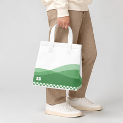 Stockka medium non-woven polypropylene tote bag with white handles and a green wave design with a clover.