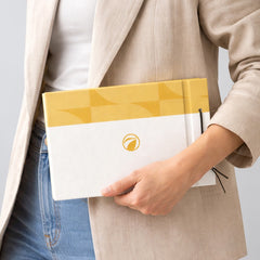 Stockka horizontal hard cover notebook with white and gold checkered design, featuring a string closure and a logo.