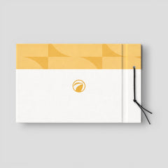 Stockka horizontal hard cover notebook with a yellow geometric pattern and a white textured front, featuring a gold leaf logo and black string closure.