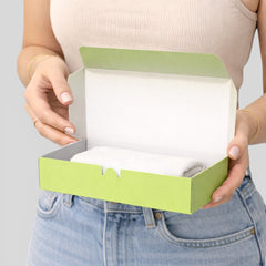 Stockka lime green rigid cardboard gift box with magnetic closure, holding a folded white towel.