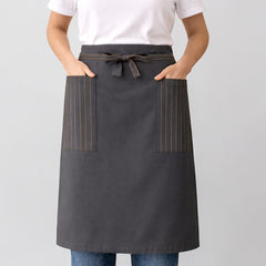 Stockka long dark grey cotton-polyester blend waist apron with two side pockets featuring pinstripe detail and a tie waist.