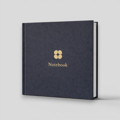 Stockka navy blue hardcover notebook with gold cloverleaf logo and 'Notebook' text. 80 lined pages.