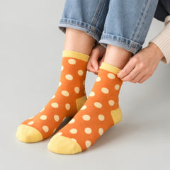 Stockka orange mid-calf socks with white polka dots and yellow accents. Cotton and spandex blend for comfort.