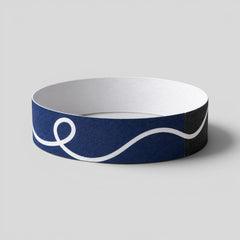 Stockka navy blue paper wristband with white wave design and adhesive closure, ideal for events.