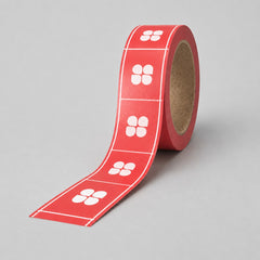 Stockka red rectangular custom stickers on a roll, featuring a white four-petal flower design, ideal for product labeling.