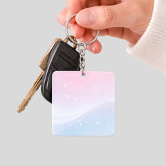 Stockka square acrylic keychain with pink and blue gradient and sparkling stars, attached to car keys.