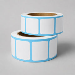 Stockka white square labels with rounded corners on a roll, featuring a light blue border. Ideal for product marking, packaging, and shipping.