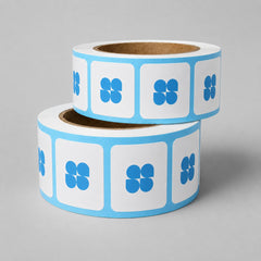 Stockka rolls of square stickers with rounded corners and blue cloverleaf logo. White stickers with blue border.