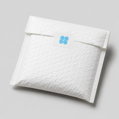 Stockka white square stickers with rounded corners and blue logo on a padded envelope.