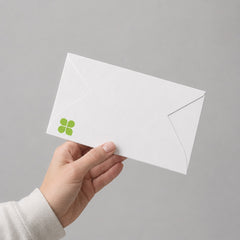 Stockka white 250gsm cardstock envelope with a secure interlocking closure held in a hand