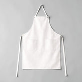 Stockka full length white cotton-polyester blend apron with two front pockets and adjustable waist ties.