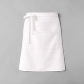 Stockka white polyester-cotton blend waist apron with a large front pocket and long tie straps for cafes and restaurants.