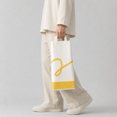Stockka white paper gift bag with yellow accent and logo, perfect for wine or alcohol bottles.