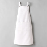 Stockka white cotton-polyester blend work apron with two large front pockets and metal ring shoulder straps.