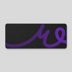 Stockka wide black desk mat with a purple wavy line design, suitable for mouse and keyboard.