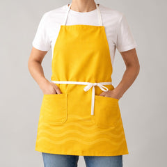 Stockka full-length yellow cotton-polyester blend apron with three pockets and a wave pattern.