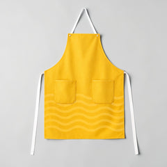 Stockka yellow full-length apron with three pockets and a subtle wave pattern. Made from a cotton-polyester blend.