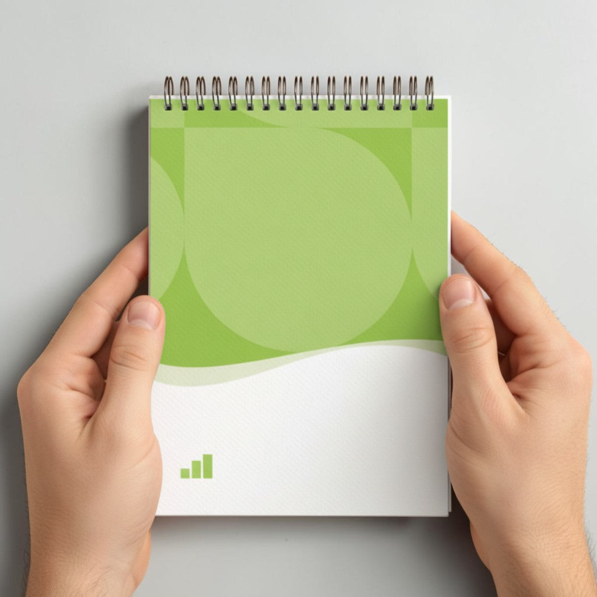 Stockk vertical spiral notebook with green abstract design, 80 lined pages, soft spiral binding.