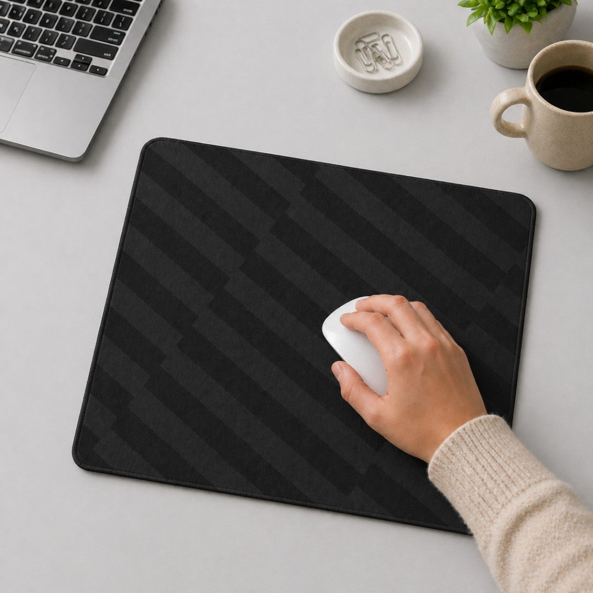 Stockka black rectangular mouse pad with a subtle geometric pattern, used by a hand with a white mouse.