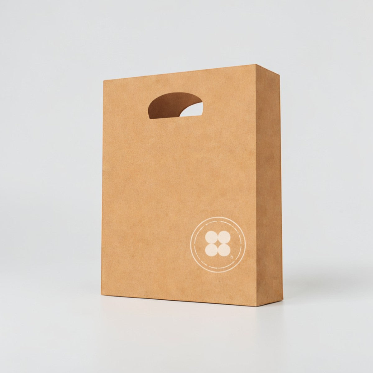 Stockka brown kraft paper bag with die-cut handle and circular logo, ideal for retail and branding.