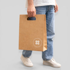 Stockka brown kraft paper shopping bag with die-cut handles and a circular logo, ideal for retail and branding.