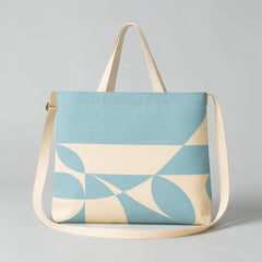Stockka light blue and cream canvas messenger bag with geometric pattern and adjustable strap.