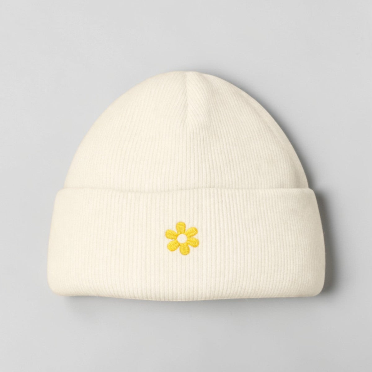 Stockka cream acrylic beanie with yellow embroidered flower detail. Double knit for warmth.