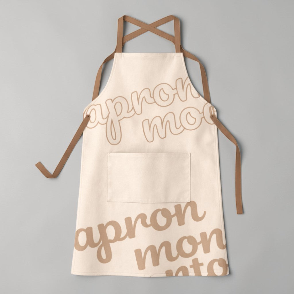 Stockka full-length apron in cream cotton-poly blend with brown cross-back straps and a large front pocket.