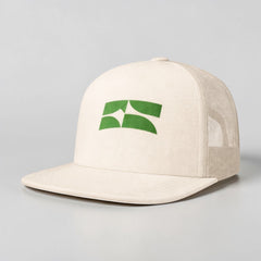 Stockka cream cotton mesh trucker hat with flat brim and green logo detail. Breathable mesh back.