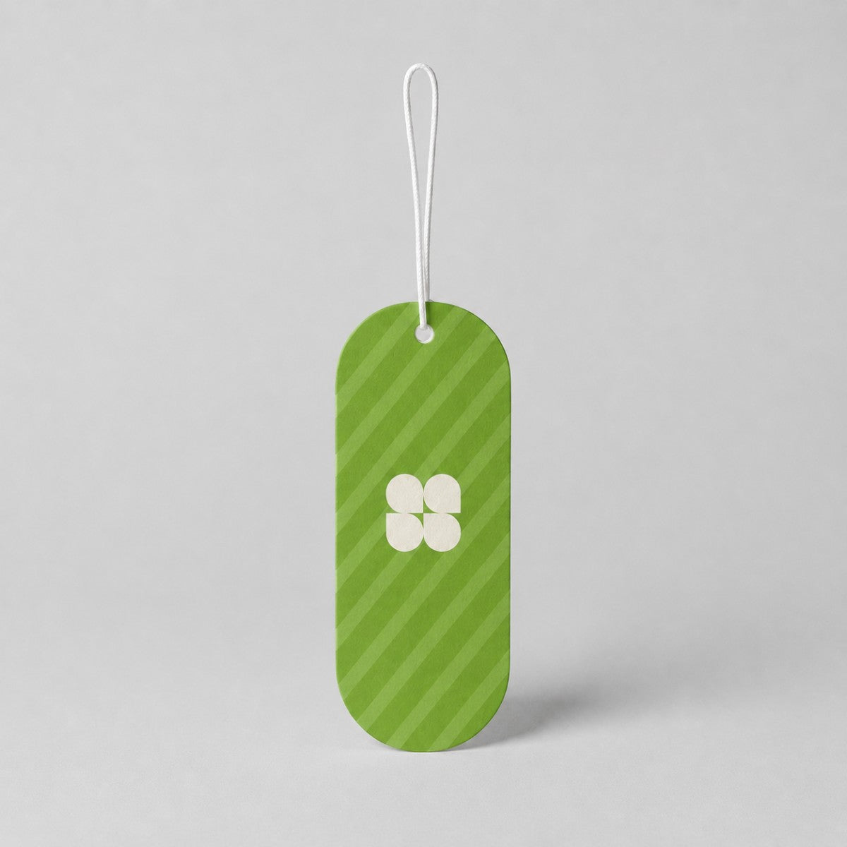 Stockka custom branded hang tag with green stripes and a white four-petal logo, made of cardstock.