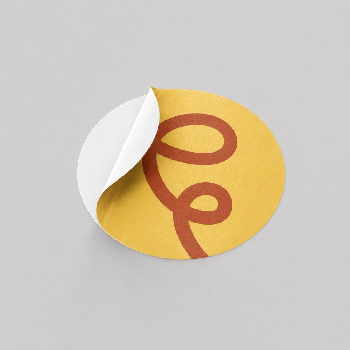 Stockka yellow round sticker with a burnt orange swirl design, ideal for branding products and packaging.