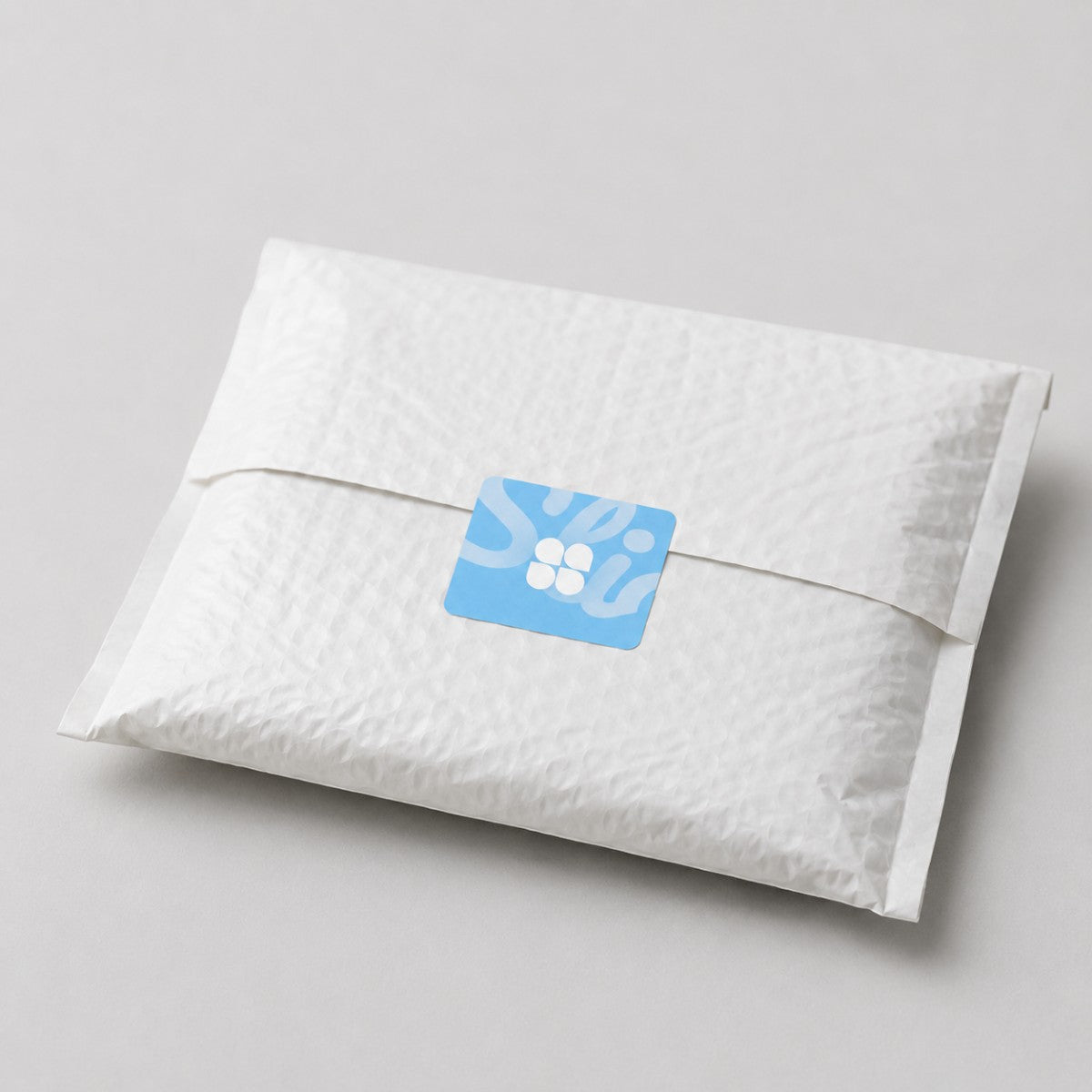Stockka custom square sticker with rounded corners, blue with white graphic, on a white textured envelope.