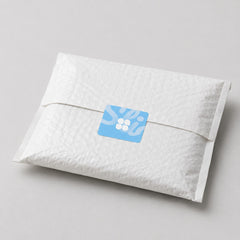 Stockka custom square sticker with rounded corners, blue with white graphic, on a white textured envelope.