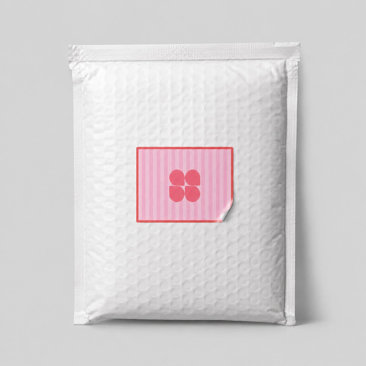 Stockka custom square sticker with pink stripes and a four-petal flower logo on a padded envelope.