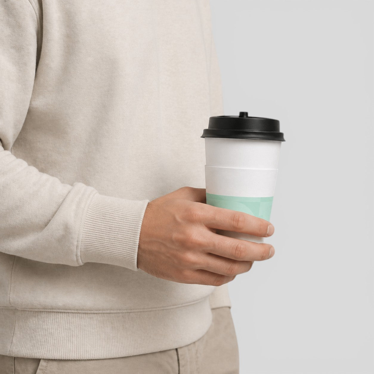 Stockka 473ml double-walled white paper cup with insulating sleeve and black lid, perfect for hot drinks.